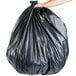 A person holding a Berry low density heavy-duty black garbage bag.