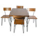 A BFM Seating steel bar height table with metal legs and four chairs.
