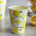 A close-up of a Carnival King lemonade paper cup with lemons on it.