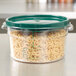 A Carlisle clear plastic food storage container with pasta inside.