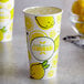 A close up of a Carnival King paper lemonade cup with lemons on it.