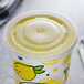 A clear plastic Carnival King lid with a straw slot over a cup with lemons on it.