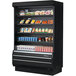 A black Turbo Air refrigerated air curtain merchandiser with food on shelves.