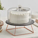 An Acopa Slate Rose Gold wire cake stand with a cake on top.