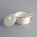 An Acopa Keystone stoneware mini casserole dish in white with brown specks and a lid.