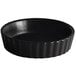 A black round Acopa Keystone stoneware dish with a wavy edge.