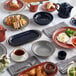 A table with Acopa Keystone stoneware rarebit dishes filled with food.