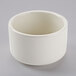 A white Tuxton eggshell china soup cup on a gray surface.