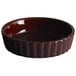 A brown ceramic Acopa Keystone Souffle / Creme Brulee dish with a wavy edge.