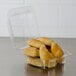 A Dart clear hinged plastic container with croissants inside.