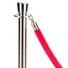 A silver pole with a red velvet rope.