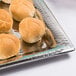An American Metalcraft hammered stainless steel tray with rolls of bread on it.