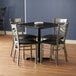 A black metal Lancaster Table & Seating dining table with chairs.