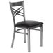 A Lancaster Table & Seating standard height dining chair with a black cushion on a black and chrome metal chair.