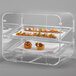A Rosseto clear acrylic two-tier bakery display case with food on trays.