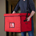 A man holding a red Cambro Stadium Delivery GoBag.