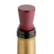 A bottle of wine closed with a Franmara burgundy wine stopper with gold trim.