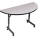 A white Correll EconoLine half round flip top table with black legs and wheels.