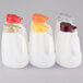A group of Tablecraft white plastic jugs with assorted white, red, and yellow lids.