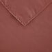 A close-up of a mauve rectangular cloth table cover with a corner.
