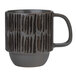 A close up of a gray stoneware mug with black and white stripes on it.