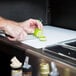 A man cutting a lime on a black tray on the Carlisle Cherry Wood Maximizer Portable Bar counter.