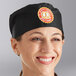 A woman smiling while wearing a black Choice mesh chef hat.