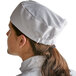 A woman wearing a white Choice chef's skull cap.
