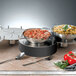 Three Bon Chef stainless steel chafers filled with food on a table.