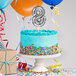 A white birthday cake with a silver "8" balloon cake topper.