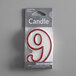 A white candle outlined in red with the number "9" in a plastic wrap package.