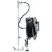 A black Equip by T&S hose attached to a metal pole with a white wall mount.