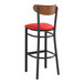 A Lancaster Table & Seating black bar stool with red vinyl seat and wooden back.
