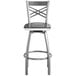 A Lancaster Table & Seating silver metal cross back bar stool with a black wood seat.