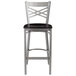 A Lancaster Table & Seating clear coat metal cross back bar stool with a black wood seat.