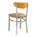 A Lancaster Table & Seating metal chair with a light brown vinyl seat and cherry wood back.