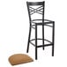 A Lancaster Table & Seating black metal cross back bar stool with a light brown cushion