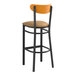A Lancaster Table & Seating black bar stool with a light brown cushion and cherry wood back.