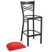 A Lancaster Table & Seating black metal bar stool with a red cushion.