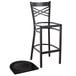 A detached black metal Lancaster Table & Seating cross back bar stool with a black wood seat.
