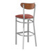 A Lancaster Table & Seating bar stool with a burgundy vinyl seat and wood back.