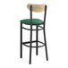 A Lancaster Table & Seating Boomerang series black bar stool with green vinyl seat and driftwood back.