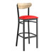 A Lancaster Table & Seating black bar stool with red vinyl seat and driftwood back.
