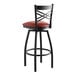 A Lancaster Table & Seating black cross back swivel bar stool with a burgundy vinyl padded seat.