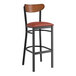 A Lancaster Table & Seating bar stool with a black finish, burgundy seat, and wood back.