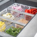 A Traulsen refrigerated sandwich prep table with food containers on a counter.