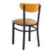 A Lancaster Table & Seating black chair with a light brown cushioned seat.