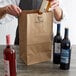 A man opening a Duro brown paper bag with bottles of wine inside.