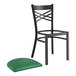 A Lancaster Table & Seating black cross back chair with a green vinyl padded seat.