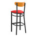 A Lancaster Table & Seating black bar stool with red vinyl seat and cherry wood back.